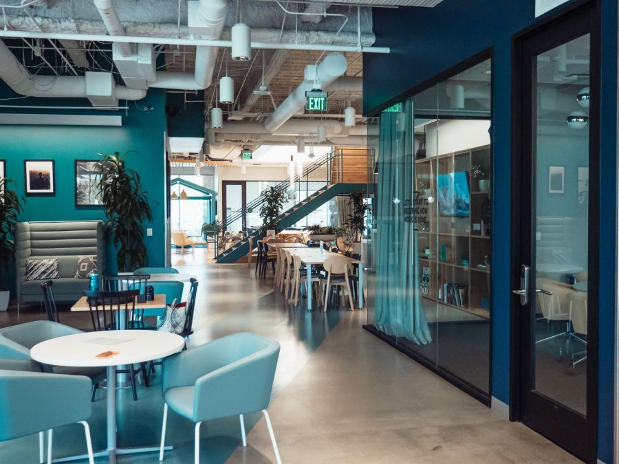 A coworking lounge with a glass-walled meeting room