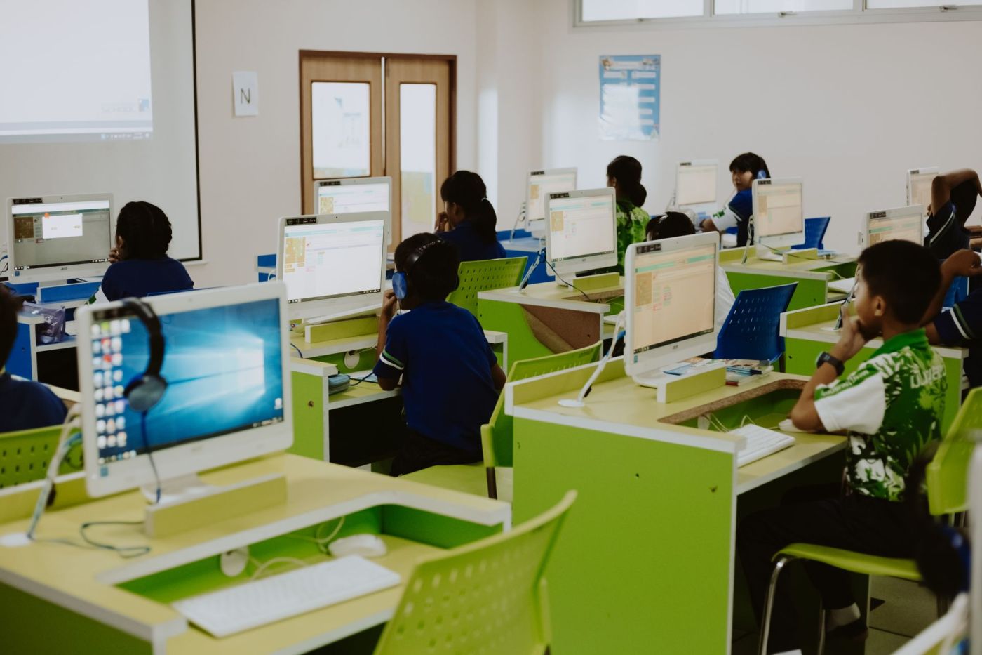 Students working at a row of desktop PCs in a school computer lab
